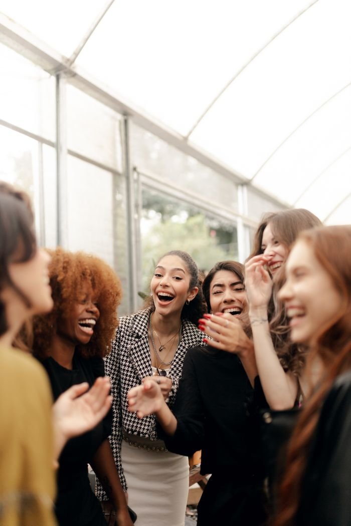 A group of young adults laughing and celebrating indoors, showcasing camaraderie and happiness.